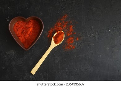 red hot chili peppers powder in heart shaped bowl on black stone table. Love concept. Top view flat lay with copy space - Powered by Shutterstock