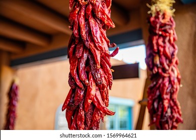 Red hot chili peppers ristras dried bunch hanging on a traditional building entrance, Santa Fe New Mexico - Powered by Shutterstock