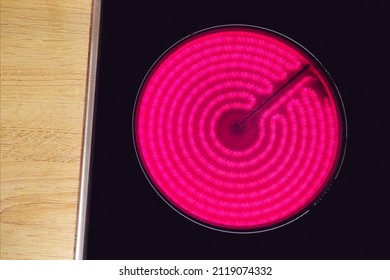 Red hot glass ceramic cooktop burner flame. Glowing burner of the electric hotplate, top view