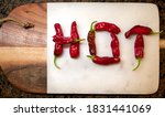 Red Hot Peppers on Cutting Board spelling the work HOT.