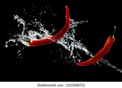 Red hot peppers in water splash over black background