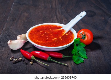 Red Hot Sweet Chilli Sauce Over Old Wooden Background