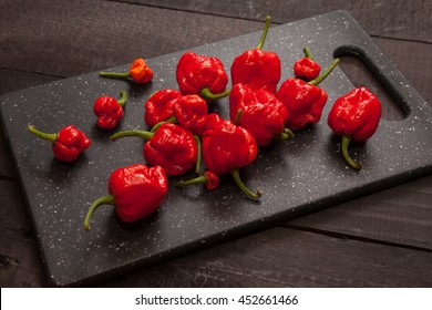 Red hot Trinidad moruga scorpion peppers black cutting board