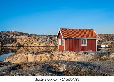 Red House At Sea Shore In The Baltic Sea. Old Small Fish House In Sweden