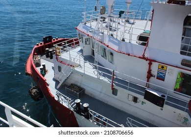 Red hulled standby safety vessel in ship to ship operation. It is used to refuel and resupply seismic survey vessels during oil and gas exploration. - Shutterstock ID 2108706656
