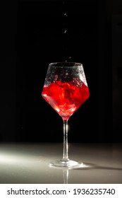 A Red Iced Drink Is Poured Into A Glass With A Splash