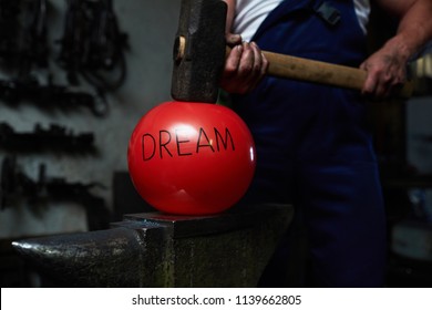 Red inflated ball with note dream situated between anvil and big hammer held by blacksmith - Powered by Shutterstock