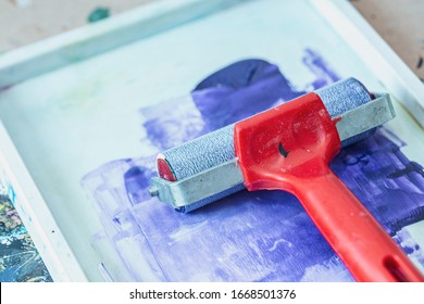 Red Ink Roller And Splashed Blue Paint In Tray - Creative Printmaking Tools