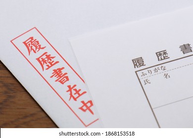 Red Japanese characters on a white envelope. Translation: with resume, resume, furigana, name.