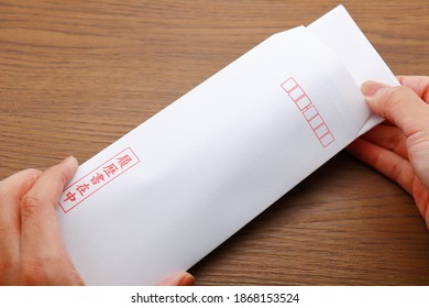 Red Japanese characters on a white envelope. Translation: with a resume.