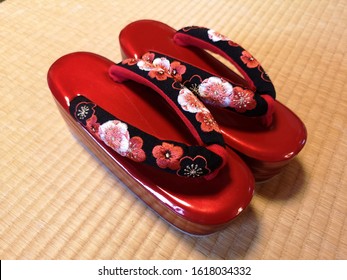 Red Japanese Shoe For Yukata And Kimono Dress On The Katami Mat. Ume Flower Pattern On The Shoe.