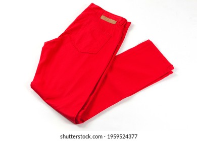 Red jeans pants isolated on white background. Folded casual style trousers 