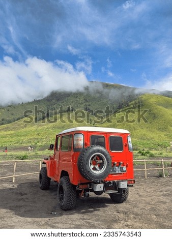 red jeep car is parked in mountain valley
