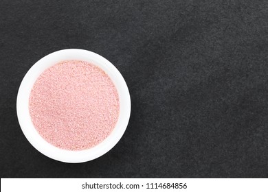 Red jelly or jello powder in small bowl on slate, photographed overhead with copy space (Selective Focus, Focus on the jelly powder)