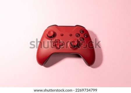red joystick gamepad, game console on pink colourful trendy modern fashion pin-up background. Computer gaming competition videogame control