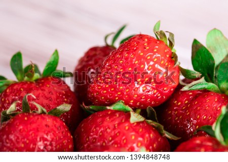 Red juicy strawberry lies on a saucer. Seasonal berries.