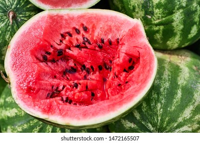 Red Juicy Watermelon Cut In Half Closeup With Seeds. Sliced Watermelon In The Middle For A Taste Test.