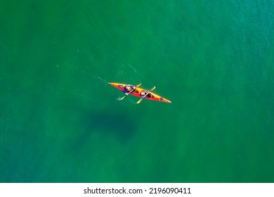 Red Kayak Boat Two Rowers On Blue Turquoise Water Sea, Sunny Day. Concept Banner Travel, Aerial Top View.