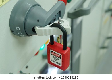 Red Key Lock And White Tag For Process Cut Off Electrical On Control Panel In Substation At Chemical Plants, Power Plants, Oil & Gas Industry Or Onshore Industry. Isolation Tag And Do Not Remove Tag.