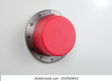 the red kitchen timer is magnetized to the white wall of the refrigerator or stove. homemade cooking concept, copy space, close up, selective focus