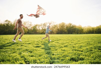 Red kite. Happy father with son are having fun on the field at summertime. - Powered by Shutterstock - Get 15% off with code: PIKWIZARD15