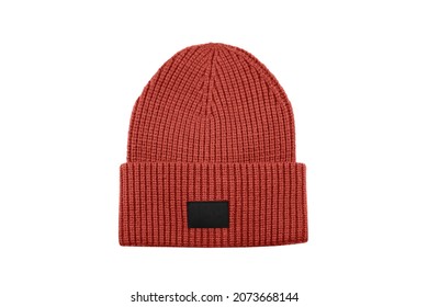 Red knitted beanie hat with black unbranded mockup label isolated on white background.