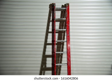 Red Ladder Leaning Against Wall