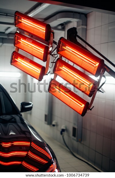 red\
lamps for drying the ceramic coating are behind\
car