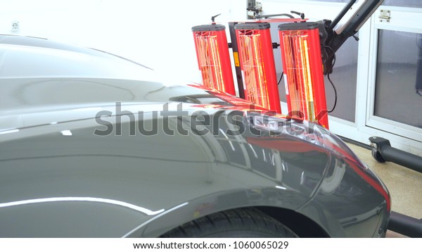 Red lamps for drying the machine after painting or\
ceramics, gray car body.