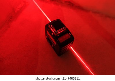 Red Laser Level Turned On In A Dark Room