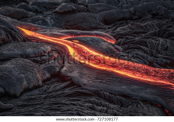 溶融した暗い背景に黒い火山地面から赤い溶岩流 の写真素材 今すぐ編集