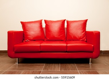 Red leather sofa with pillow. Red Divan