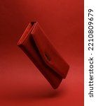 Red leather wallet Levitating in the air or hovering on red background with shadow. Minimal fashion concept