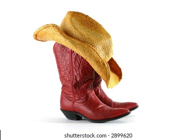 Red leather western boots with straw hat isolated on white