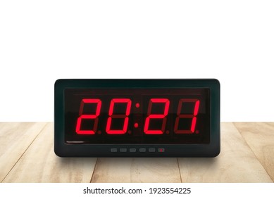 Red Led Light Illuminated Numbers 2021 On Digital Electric Alarm Clock Face On Brown Wooden Table Isolated On White Background, Time Symbol For Beginning Or End Of The Year, Close Up With Copy Space