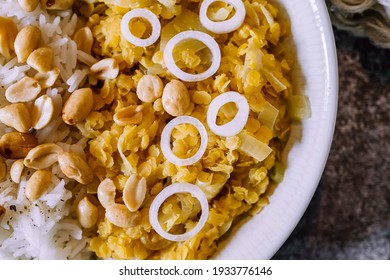 Red Lentil Dahl Dish With Peanuts And Fresh Onions Accompanied By Rice