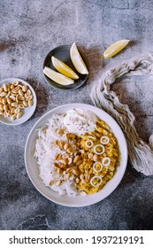 Red Lentil Dahl Dish With Peanuts And Fresh Onions Accompanied By Rice