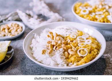 Red Lentil Dahl Dish With Peanuts And Fresh Onions Accompanied By Rice