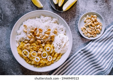 Red Lentil Dahl Dish With Peanuts And Fresh Onions Accompanied By Rice