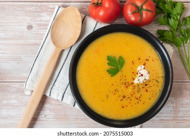 Red Lentil Puree Soup In A Plate With A Wooden Spoon. View From Above.