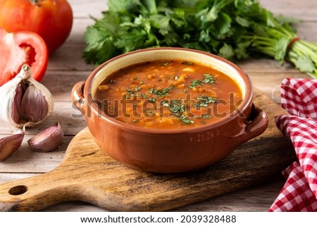 Red lentil soup in bowl on wooden table