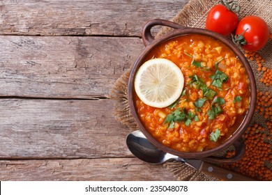 red lentil soup with lemon and vegetables close-up on the table. horizontal view from above