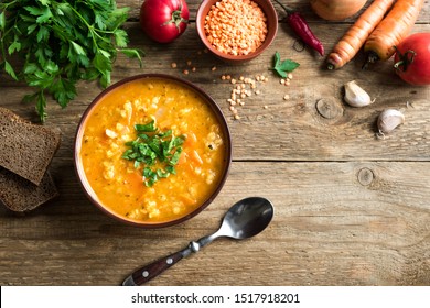 Red Lentil Soup on wooden background, top view, copy space. Traditional turkish or arabic lentil and vegetable spicy soup, healthy vegan food.