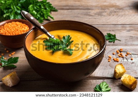 Red lentil soup on wooden background close up. Traditional middle eastern, turkish , ramadan cuisine. Vegan food .