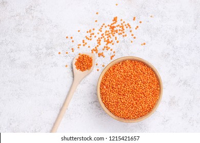 Red Lentils In Wooden Plate And Spoon On White Stone Background. Vegetarian Super Food. Top View. Flat Lay.