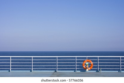 Red Lifebuoy in front of the blue sea and the white ship