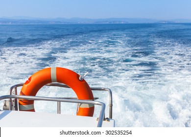 Red Lifebuoy Hanging On Stern Railings Of Fast Safety Rescue Boat