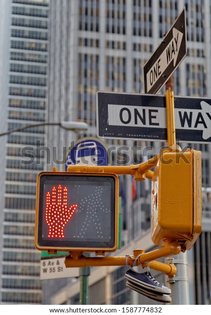 Red light for\
pedestrians at the roadside. One-way panel above. New York.  United\
States. June 2013.