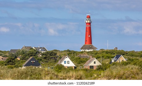 Red lighthouse between houses of village of Schiermonnikoog isand - Powered by Shutterstock