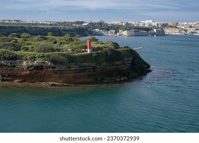 red lighthouse on L'Illa del Rei hospital island in the middle of the main navigable entry channel to Mahon in Menorca in the Mediterranean sea